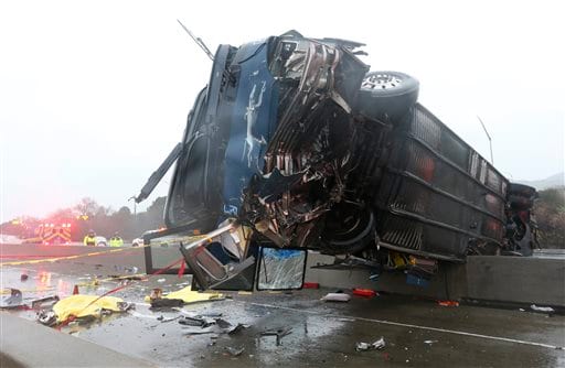 EDS NOTE: GRAPHIC CONTENT - Bodies, left, are covered with tarps as officials work at the scene of a fatal bus accident, Tuesday, Jan. 19, 2016, in San Jose, Calif. The bus flipped on its side while traveling north on Highway 101, according to the San Jose Fire Department. (Gary Reyes(/San Jose Mercury News via AP) MAGS OUT; NO SALES; MANDATORY CREDIT