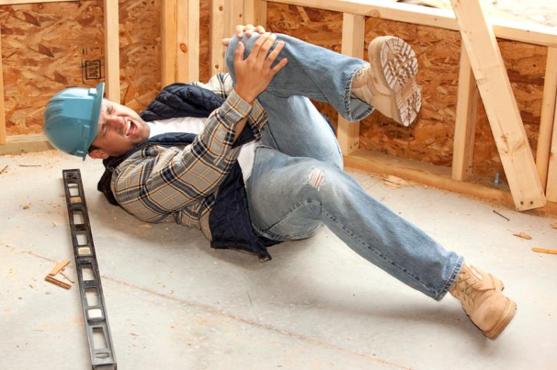 Construction man holding his knee after construction accident