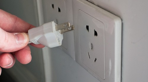 person putting plug into outlet - potential defective product