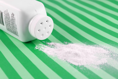 Talcum baby powder spilled out on green sheet