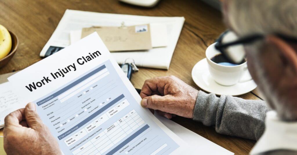 Man evaluating workers’ compensation claim form