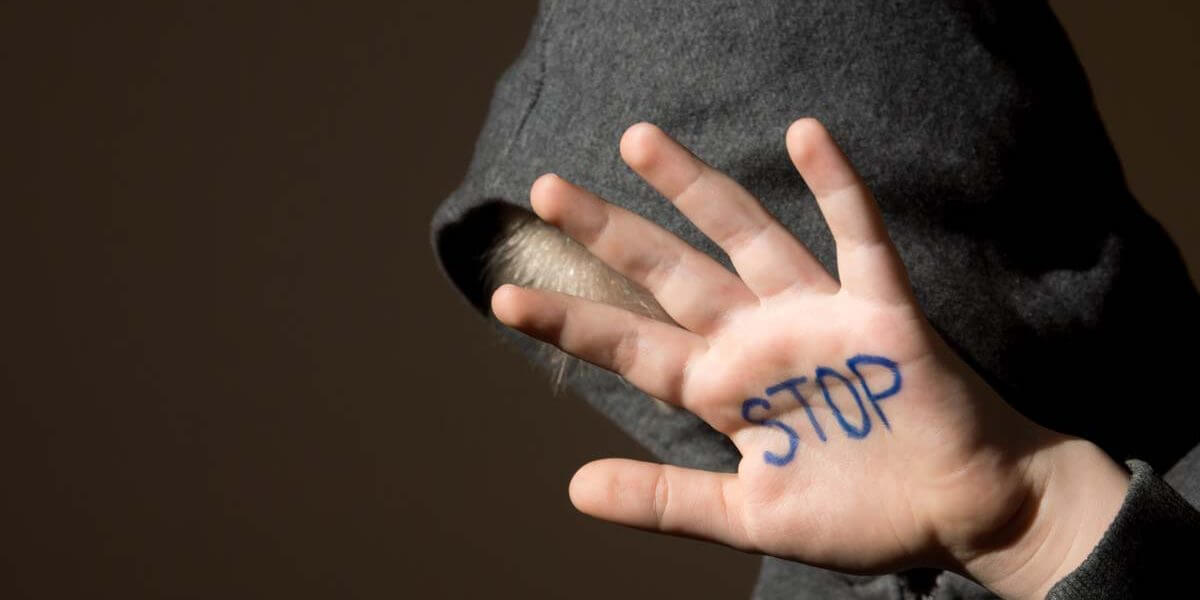 “STOP” written on child’s hand - child abuse sign