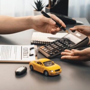 Two people calculating their car insurance claim in an office.