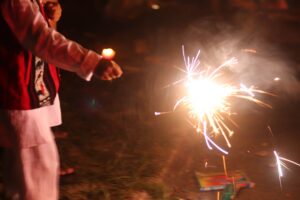 A person holding a sparkler at nighttime.