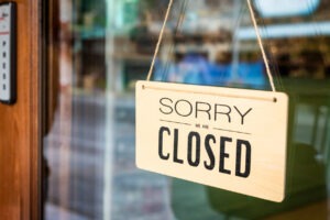 A business's glass door with a sign that says "sorry, closed."