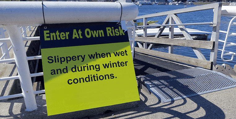 Sign in San Francisco that reads "Enter at own risk - slippery when wet and during winter conditions"