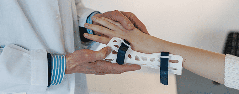 Doctor putting on wrist brace on patient