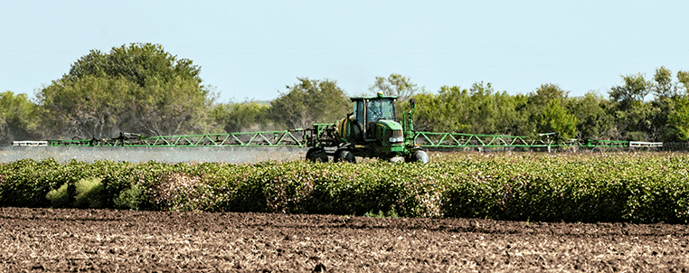 tractor spraying paraquat on crops