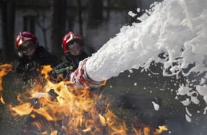 Firefighters using firefighting foam to extinguish a fire.