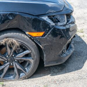 A damaged black car post-car-accident.