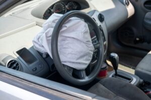 A closeup of a freshly deployed and deflated airbag in a car.