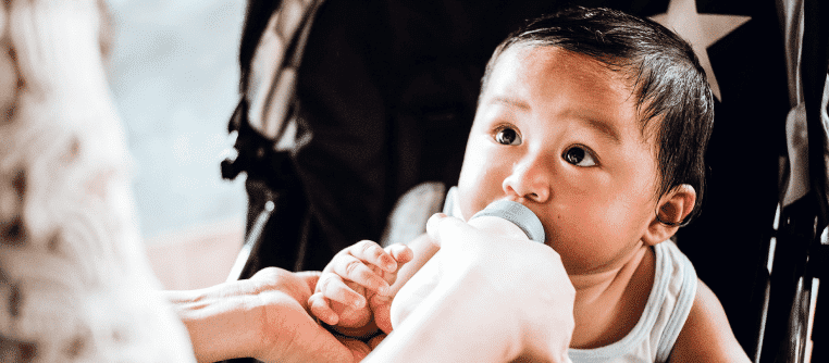 headshot of baby eating from bottle