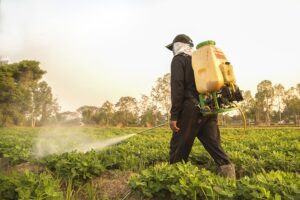 A farmer spraying pesticides on his crops.