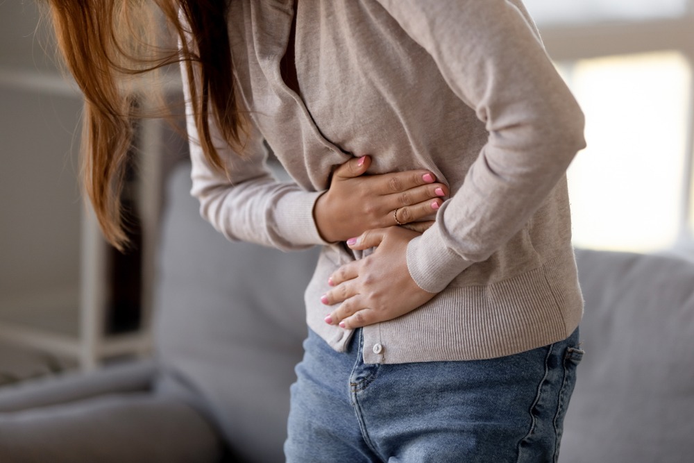 A woman clutching her stomach as a result of her paraquat poisoning.
