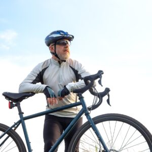 A man standing next to his bicycle.