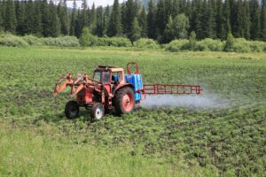 A tractor spraying pesticides on crops.