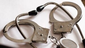 Handcuffs wrapped around a stethoscope indicating medical malpractice.