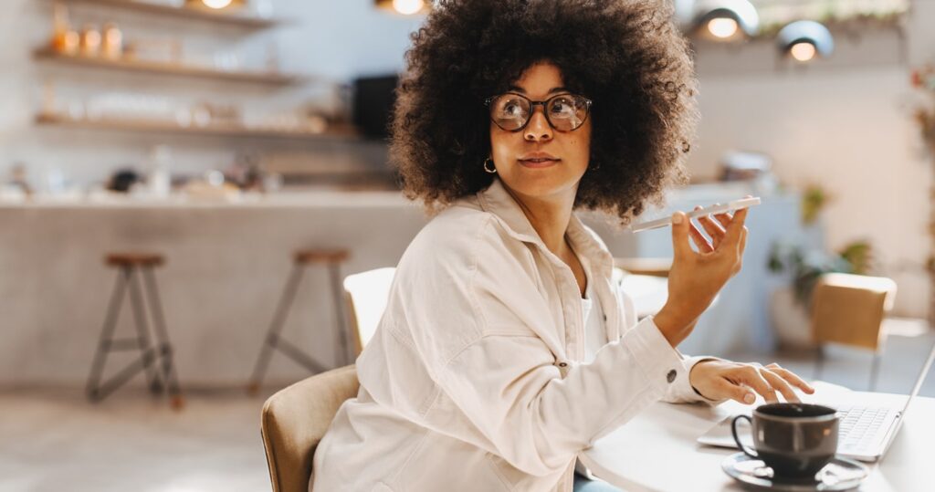 A woman with curly hair sitting at her living room table.