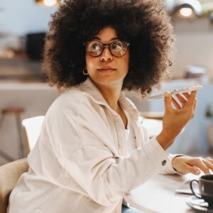 A woman with curly hair sitting at her living room table.