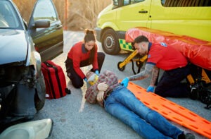 Two paramedics tending to a man injured in a rear-end collision.