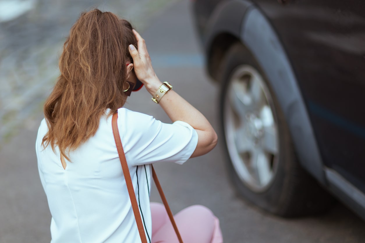 Girl stressed out next to her car that she crashed after borrowing it.