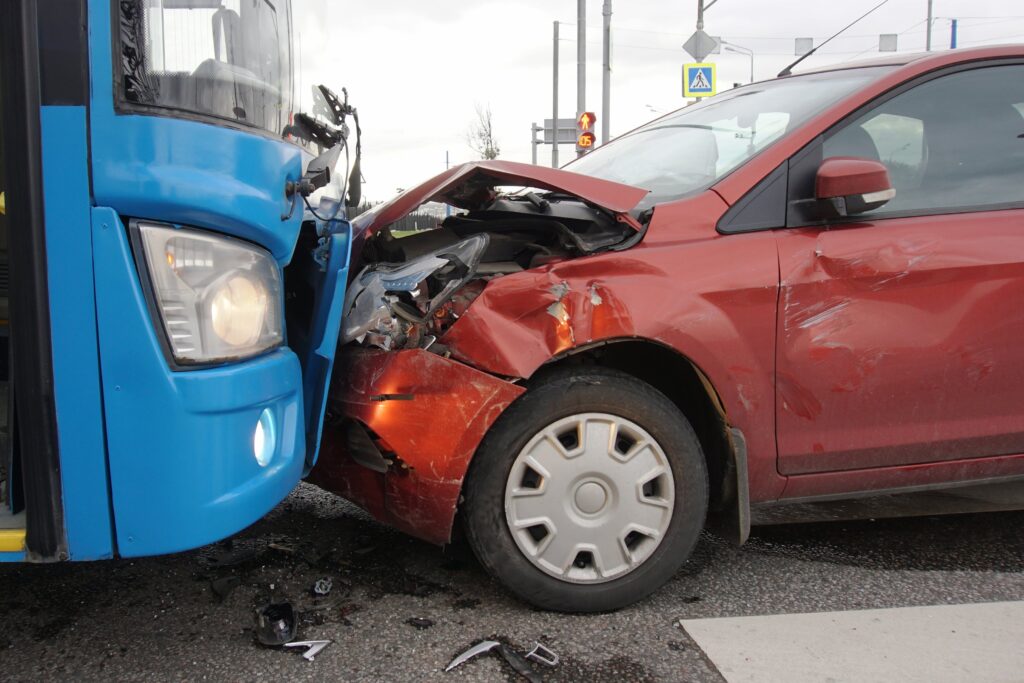 A car in a head-on auto collision with a bus.