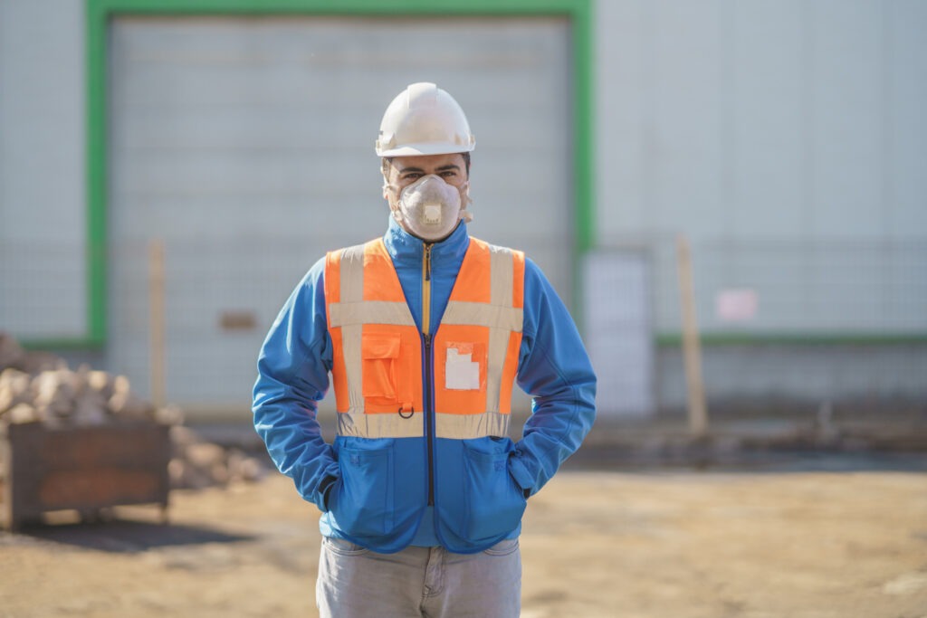 An worker in the countertop industry wearing a mask outside a factory.