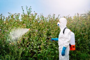 Farmer sprays crops with herbicides.