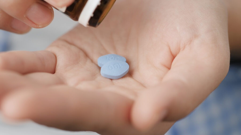 Blue Zantac pills sitting in someone's hand.