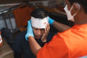 A boy with bandages wrapped around his head after an injury.