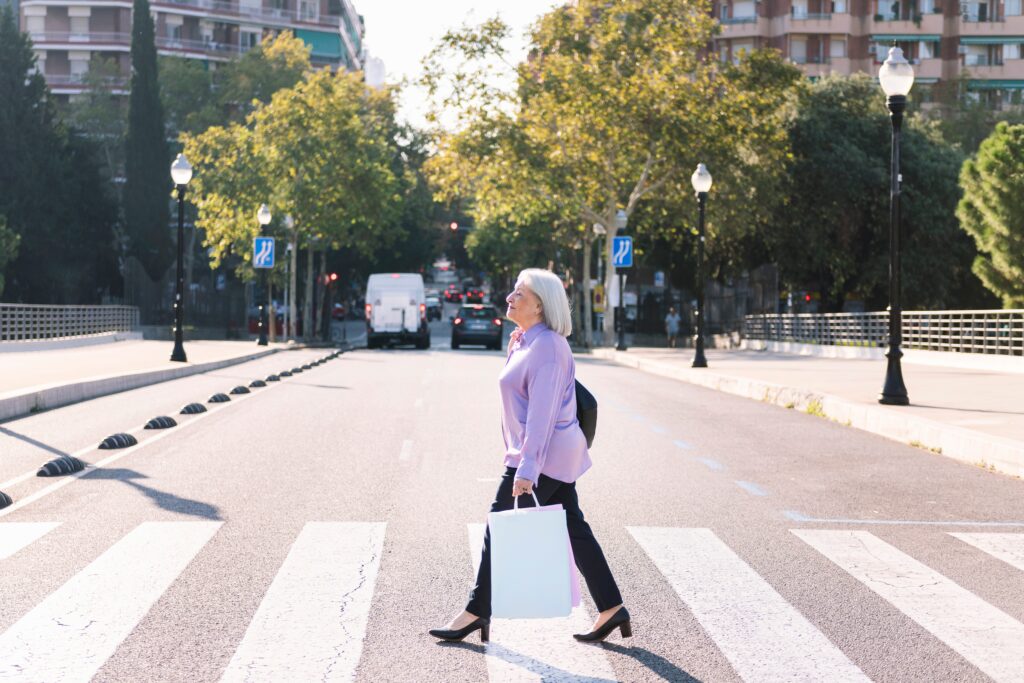 Pedestrian senior woman crossing the street in Merced.