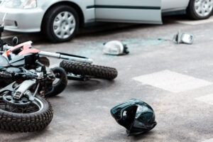 Overturned motorcycle after collision with white car.