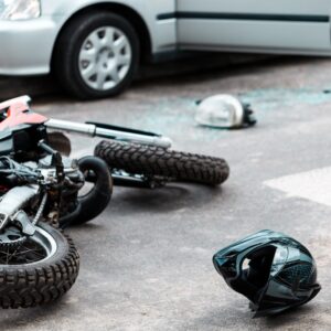 Overturned motorcycle after collision with white car.