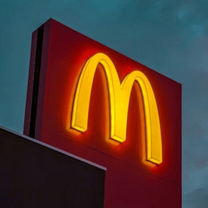 A glowing yellow "M" for McDonalds in a cloudy day.