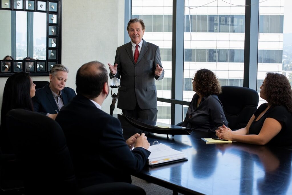 A team of lawyers sat around a table listening intently to the presentation of a senior lawyer.