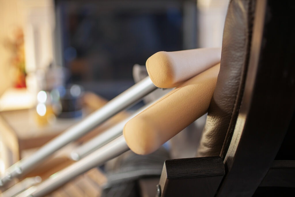 Two crutches resting on a chair in a living room.