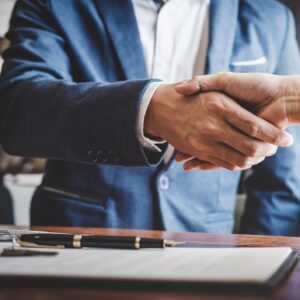 A lawyer in a blue suit shaking hands with a client.