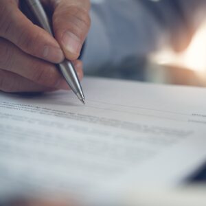 Client with pen in hand filling out a free case evaluation form in an office.