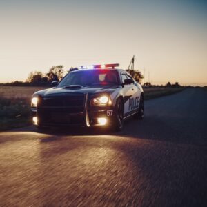 Cop car driving in the evening on an empty street.